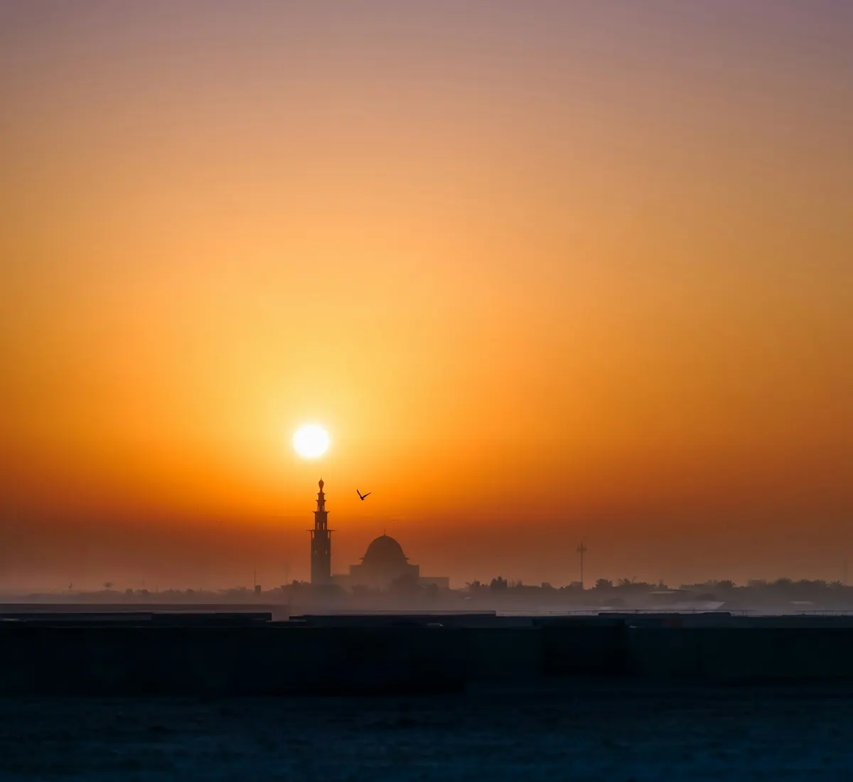 Sunrise over the Ajman coastline with a mosque silhouette